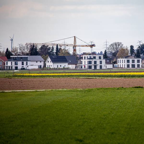 16.04.2021, Pulheim: Neu errichtete Wohnhäuser stehen am Ortsrand des Ortsrandes von Sinnersdorf während im Vordergrund landwirtschaftliche Felder zu sehen sind. Die Nachfrage nach Immobilien ist groß. Einfamilienhäuser stehen dabei wegen des hohen Flächenverbrauchs in der Kritik. Foto: Matthias Heinekamp
