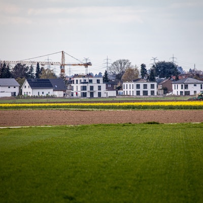 16.04.2021, Pulheim: Neu errichtete Wohnhäuser stehen am Ortsrand des Ortsrandes von Sinnersdorf während im Vordergrund landwirtschaftliche Felder zu sehen sind. Die Nachfrage nach Immobilien ist groß. Einfamilienhäuser stehen dabei wegen des hohen Flächenverbrauchs in der Kritik. Foto: Matthias Heinekamp
