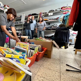 Im Ausgaberaum der "Tafel der Dinge" sortiert Leonie Djoukwe (l.) Spiele, Kleidung und Haushaltsgegenstände, die an nachweislich Bedürftige kostenlos  abgegeben werden