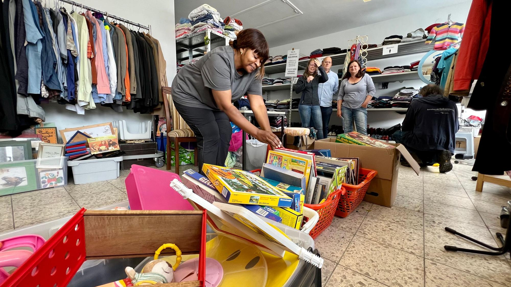 Im Ausgaberaum der "Tafel der Dinge" sortiert Leonie Djoukwe (l.) Spiele, Kleidung und Haushaltsgegenstände, die an nachweislich Bedürftige kostenlos abgegeben werden