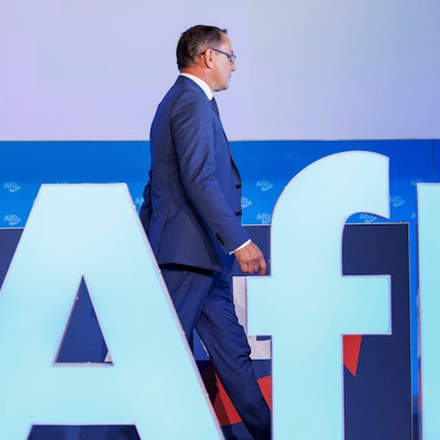 30.07.2023, Sachsen-Anhalt, Magdeburg: Tino Chrupalla, AfD-Bundesvorsitzender und Fraktionsvorsitzender der AfD, geht hinter dem AfD-Parteilogo vor der Fortsetzung der Europawahlversammlung in der Messe Magdeburg. Foto: Carsten Koall/dpa +++ dpa-Bildfunk +++