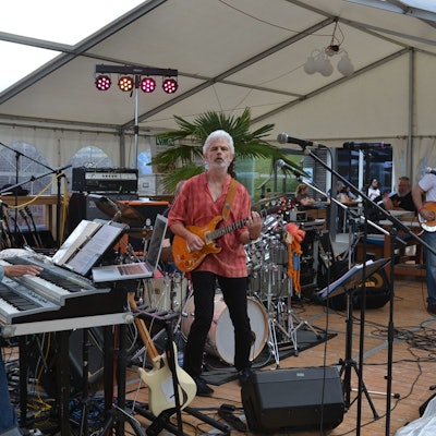 Mitglieder der Band Into Deep spielen auf einer Bühne E-Piano, Bass und Gitarre.