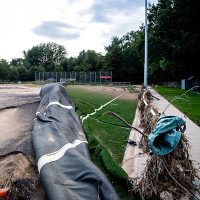 Das Foto zeigt einen vom Hochwasser zerstörten Kunstrasenplatz.