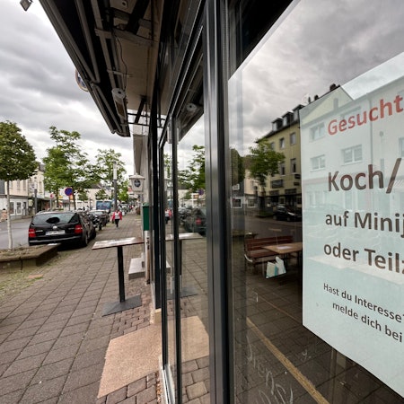 Ein Zettel hängt am Fenster eines Restaurants.