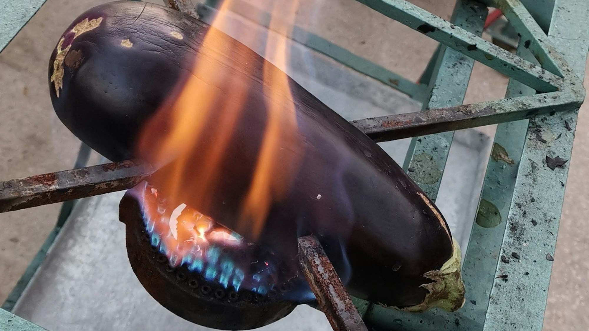 Aubergine liegt auf der Flamme eines Gasgrills