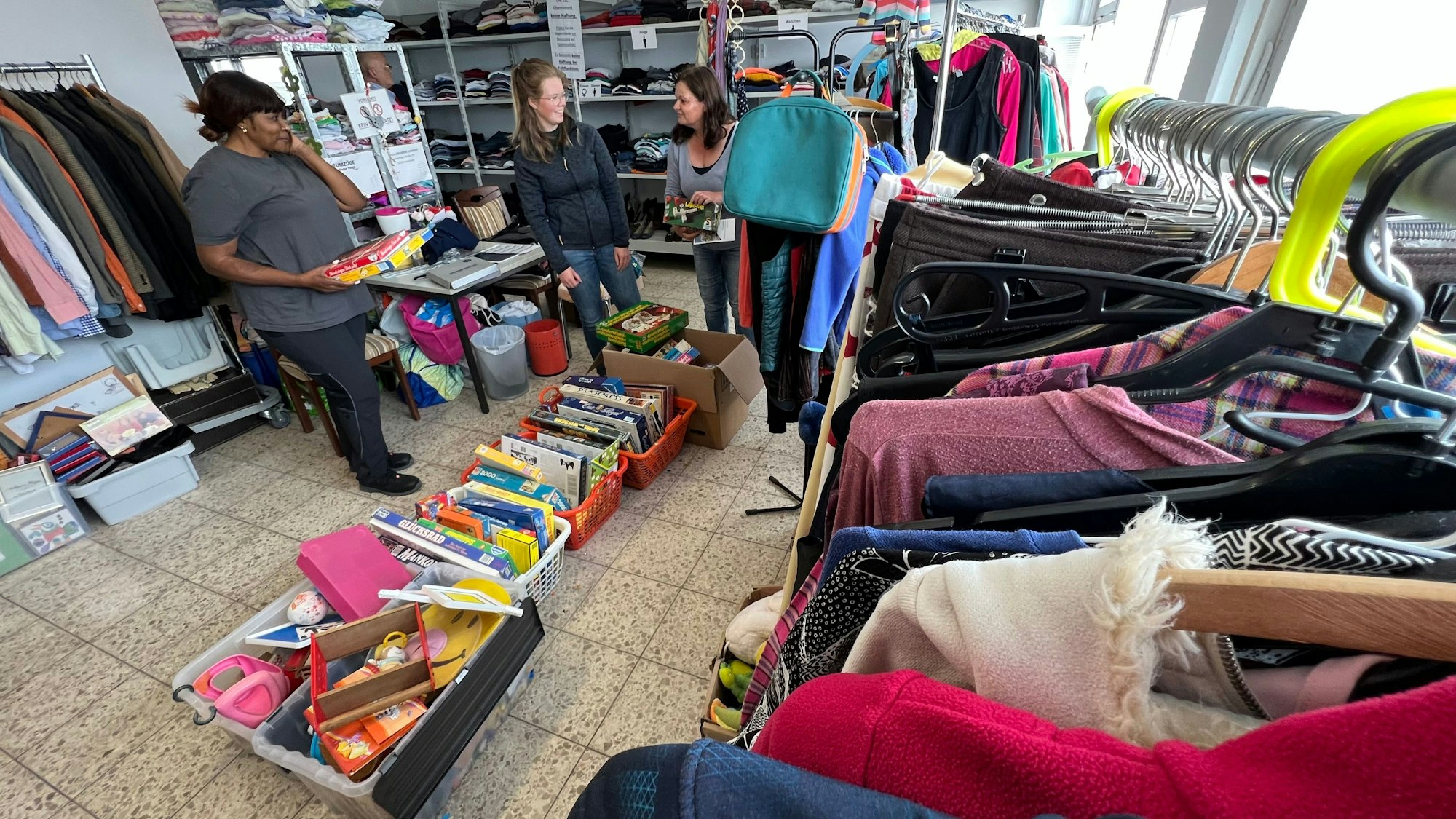 Im Ausgaberaum der "Tafel der Dinge" sortieren (v.l.) Leonie Djoukwe, Pia Wimmershoff und Marianne Ackermann Spiele, Kleidung und Haushaltsgegenstände, die an nachweislich Bedürftige kostenlos abgegeben werden