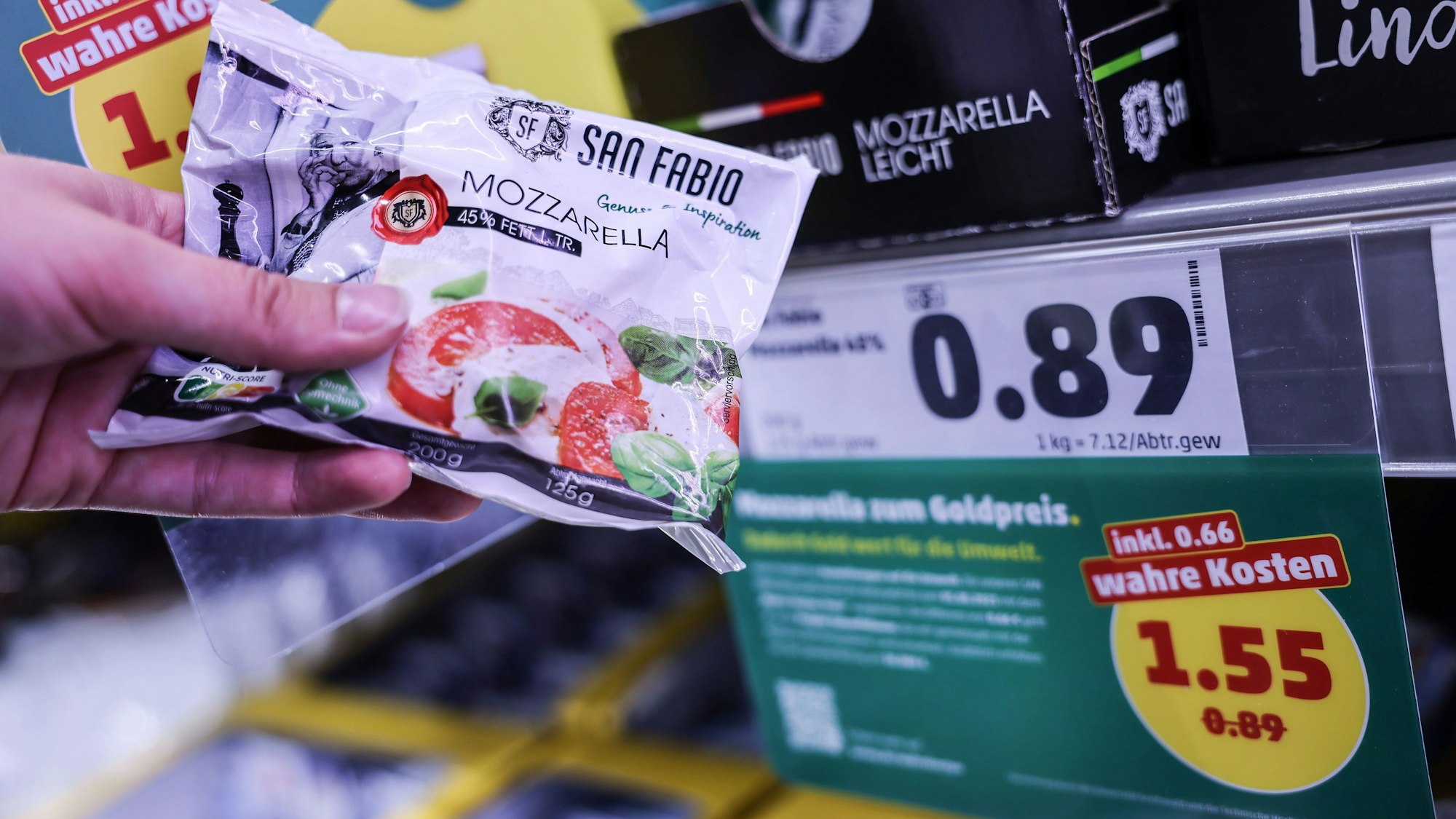 Zwei Preisschilder hängen im Kühlregal vor einem Karton mit Mozzarella.