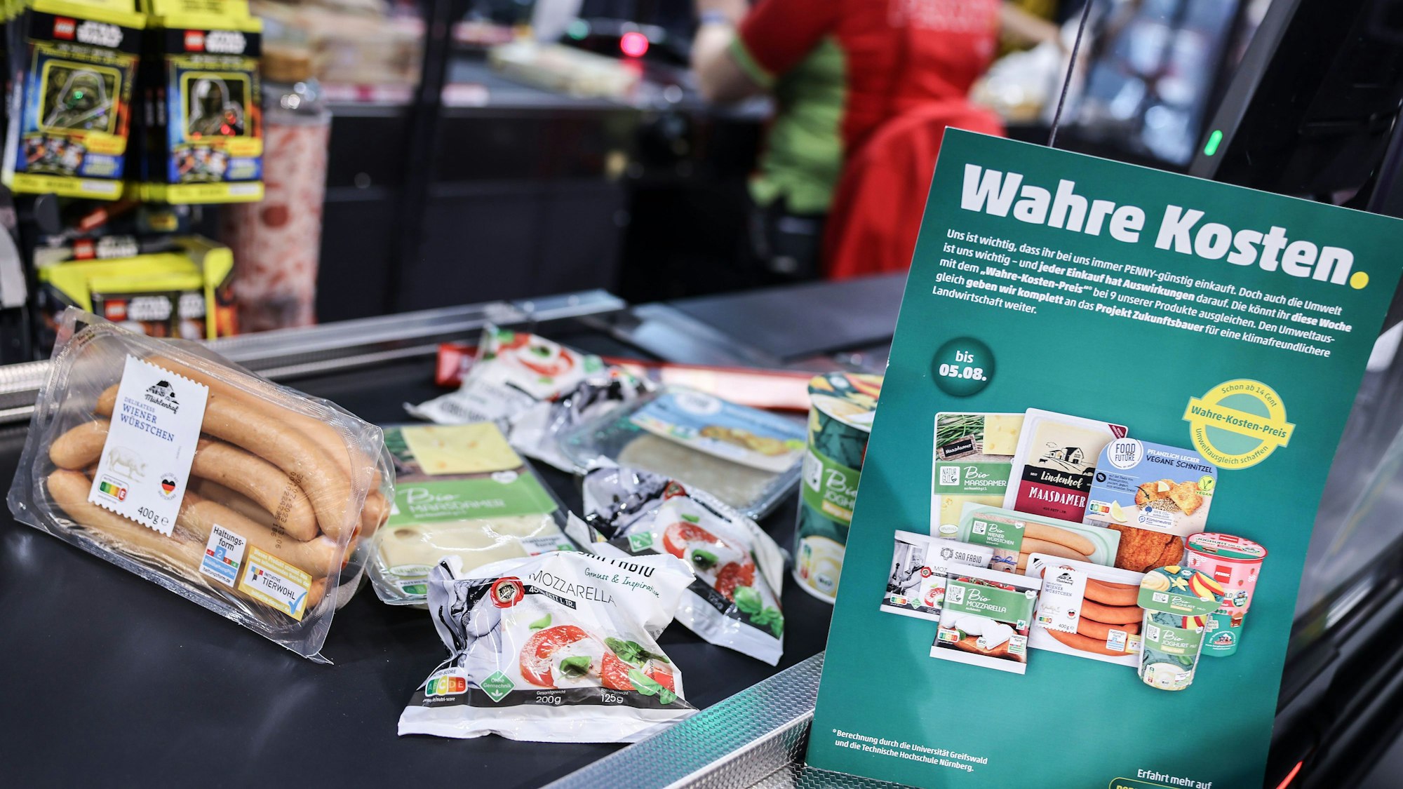 Produkte, deren Preis mit den verdeckte Kosten angepasst wurden, liegen an der Kasse.