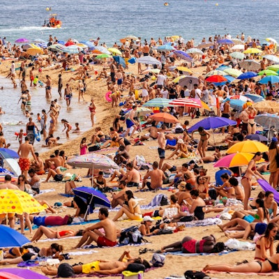 Touristen am Strand von Barceloneta.