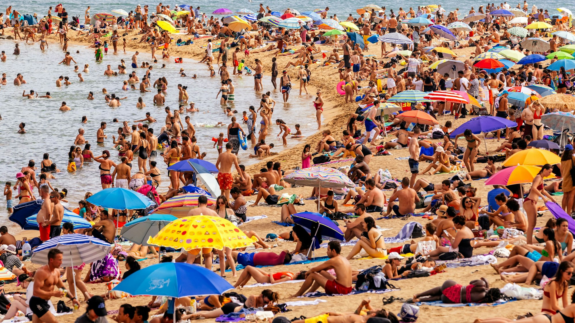 Touristen am Strand von Barceloneta.