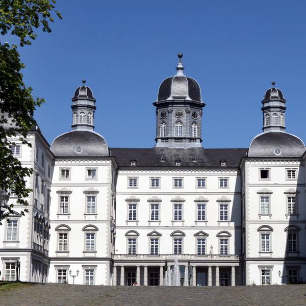 Schloss Bensberg aus der Front-Perspektive vor blauem Himmel.