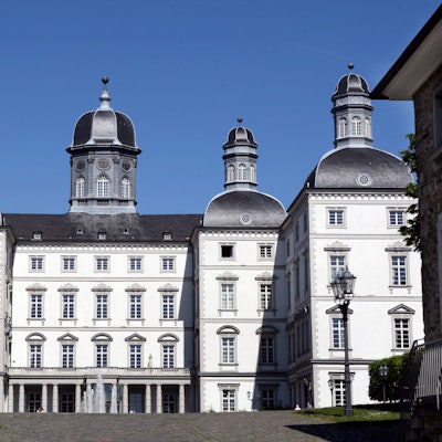 Schloss Bensberg aus der Front-Perspektive vor blauem Himmel.