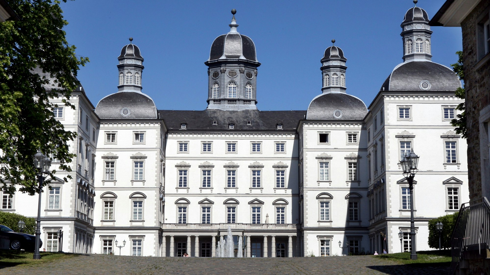 Schloss Bensberg aus der Front-Perspektive vor blauem Himmel.