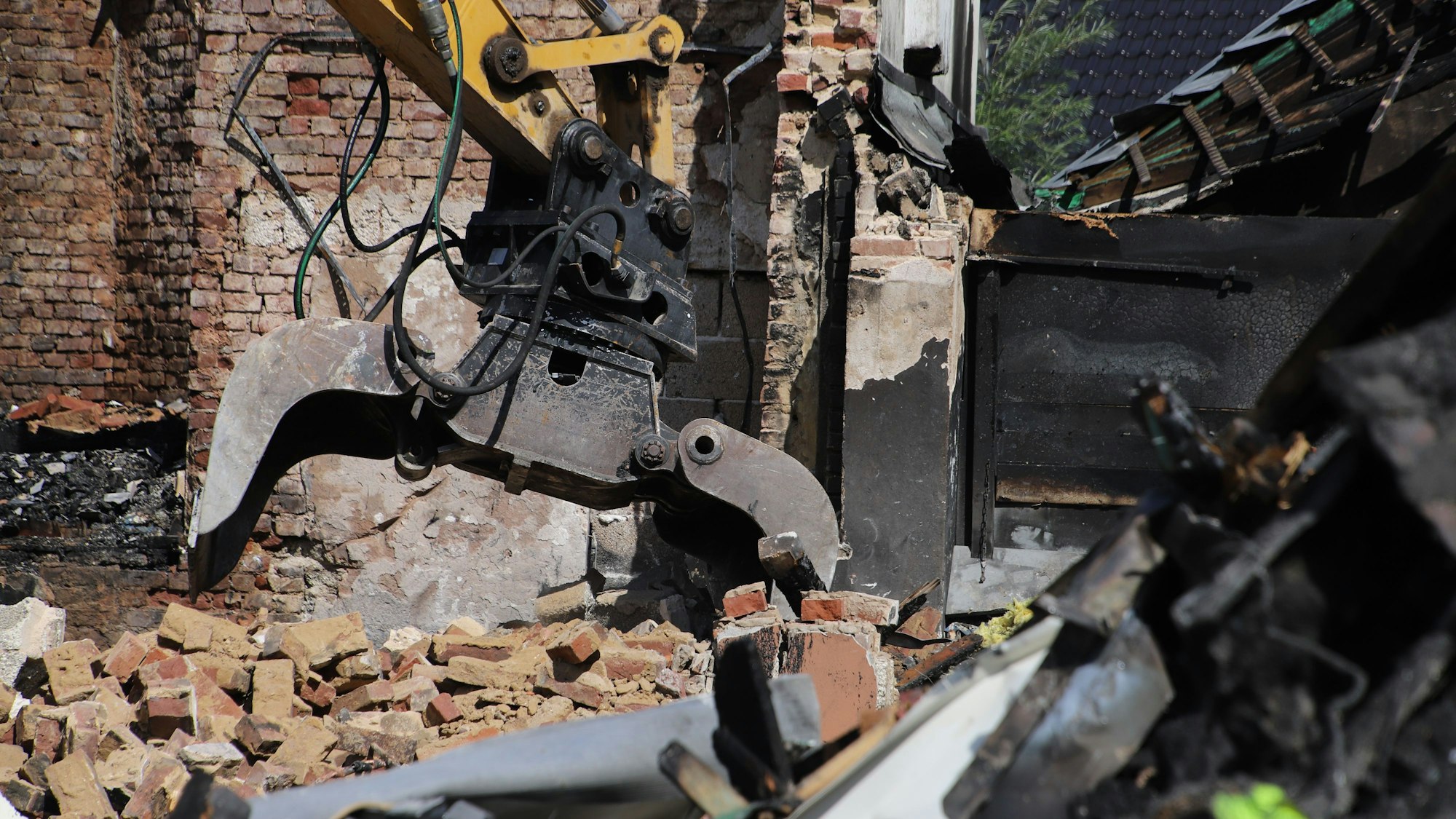 Mit der Schaufel des Baggers greift Helmut Decrouppé nach den abgebrochenen Steinen, die dann auf einen Muldenkipper geladen werden.
