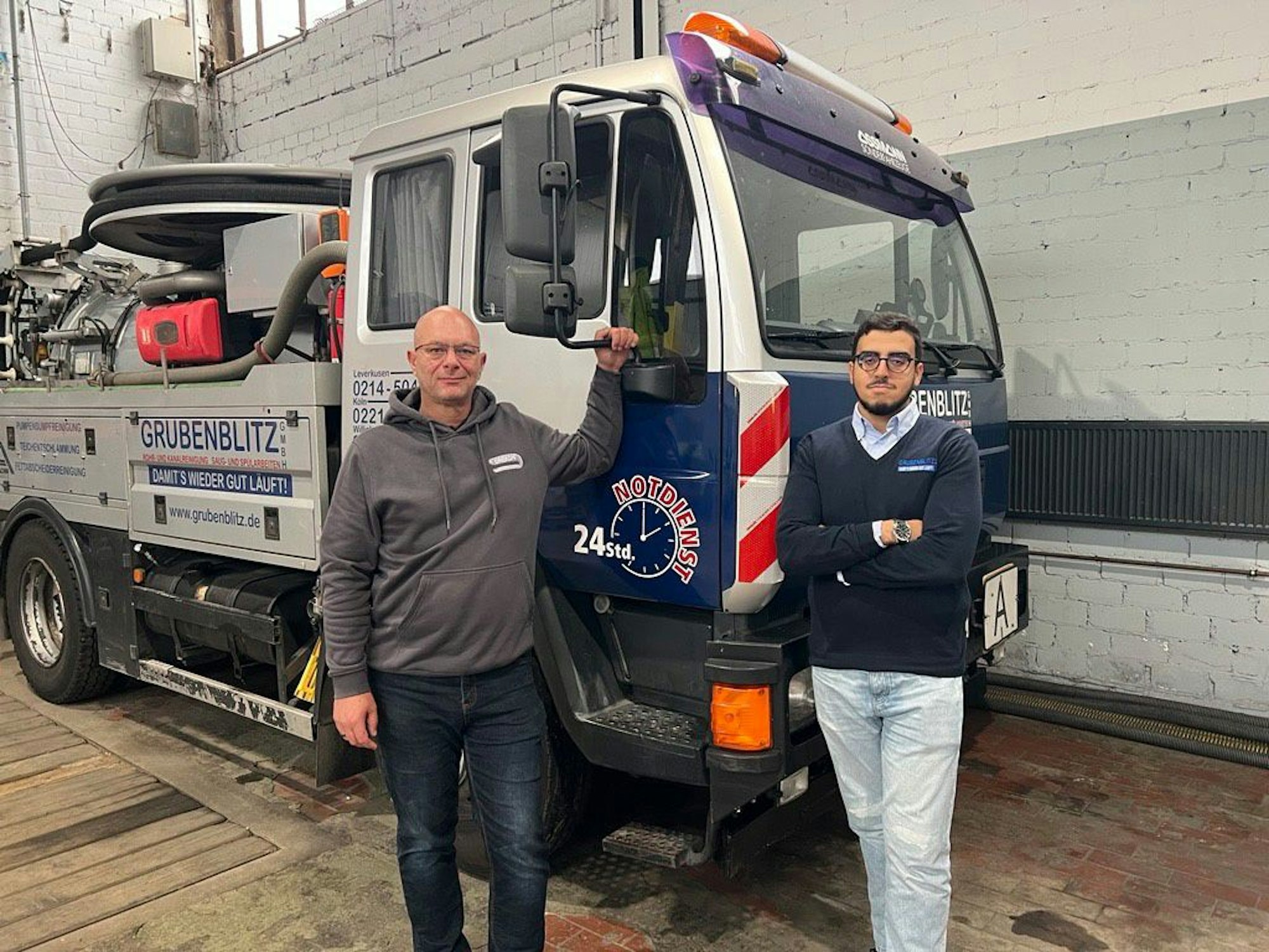 Boumadiane Ousrout (r.) und sein Ausbildungsleiter Lothar Thome vor einem Einsatzwagen der Grubenblitz GmbH