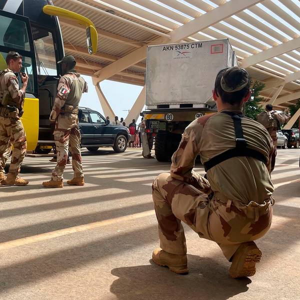 Französische Soldaten stehen neben einem Bus, der französische Staatsangehörige zum Flughafen bringt, von wo sie mit einem Militärflugzeug nach Frankreich geflogen werden sollen.