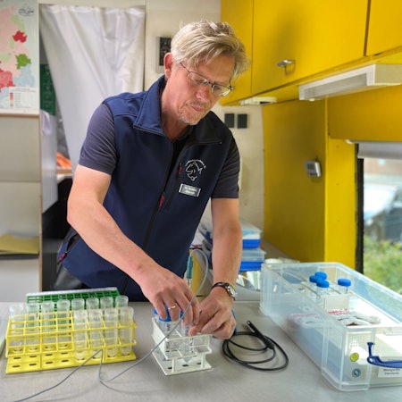 Dr. Matthias Ahlbrecht arbeitet mit Reagenzgläsern und Messgeräten.