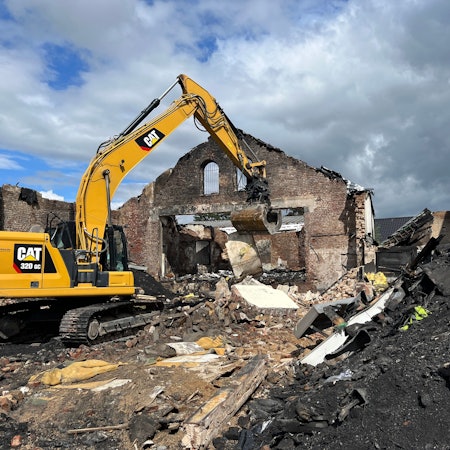 In Sankt Augustin-Niederpleis wird in den kommenden vier Wochen die Brandruine des Cycle Point abgerissen, in der bei einem Brand am 18. Juni zwei Feuerwehrleute starben. Helmut Decrouppé fährt den Bagger und trennt die Materialien voneinander.