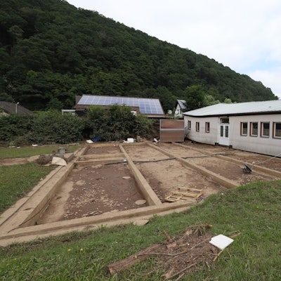 Das Bild zeigt ein Haus, das bei der Flutkatastrophe 2021 von seinem Fundament gehoben und einige Meter fortgespült wurde.