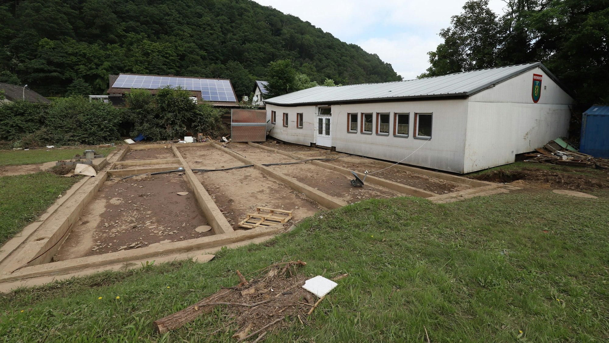 Das Bild zeigt ein Haus, das bei der Flutkatastrophe 2021 von seinem Fundament gehoben und einige Meter fortgespült wurde.