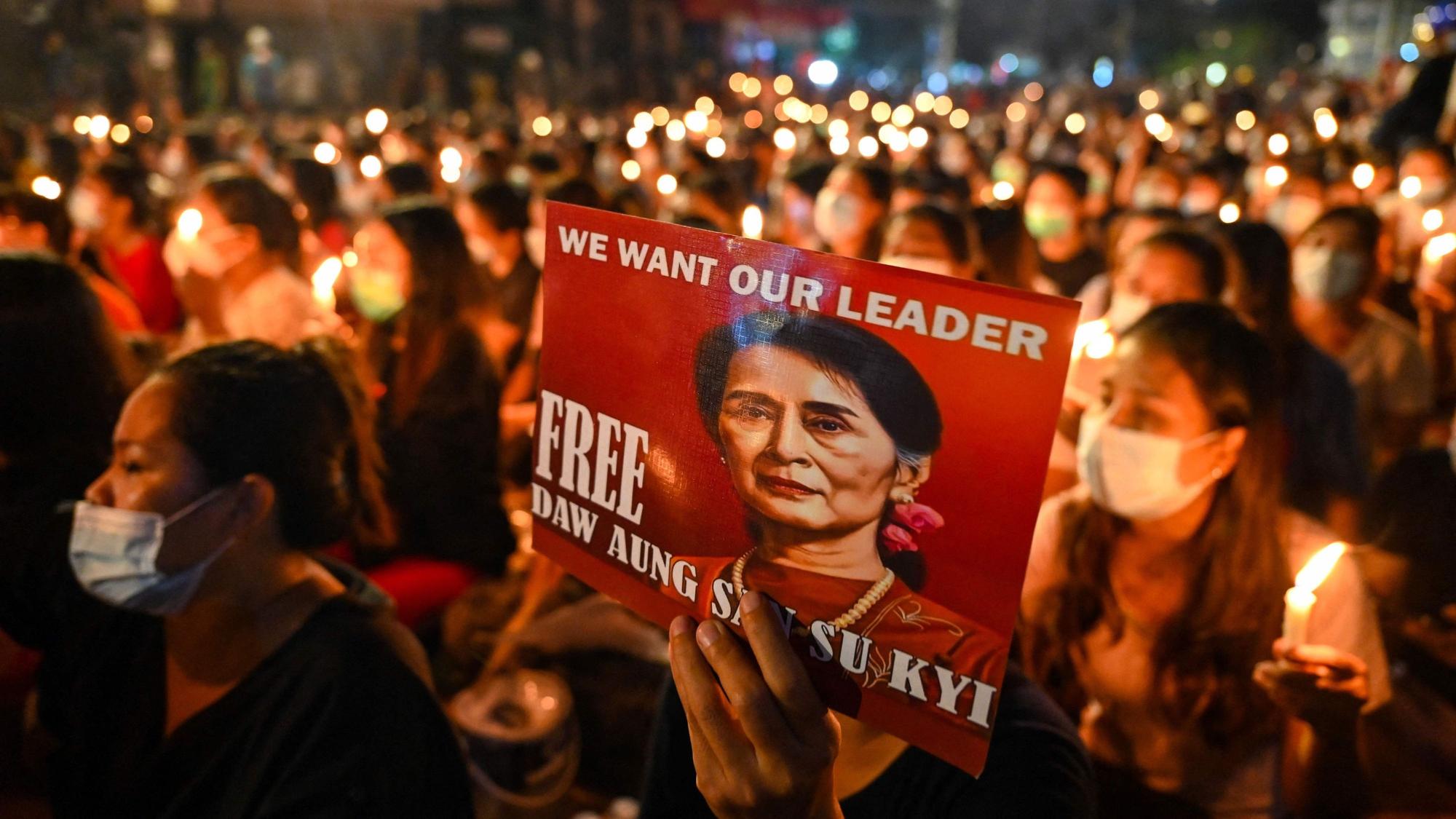 (FILES) A protester holds a poster with an image of detained civilian leader Aung San Suu Kyi during a candlelight vigil to honour those who have died during demonstrations against the military coup in Yangon on March 13, 2021. Myanmar civilian leader Aung San Suu Kyi, who has been in detention since she was ousted in a 2021 military coup, will be pardoned in a junta amnesty of more than 7000 prisoners to mark Buddhist Lent, state media said on August 1, 2023. (Photo by AFP)