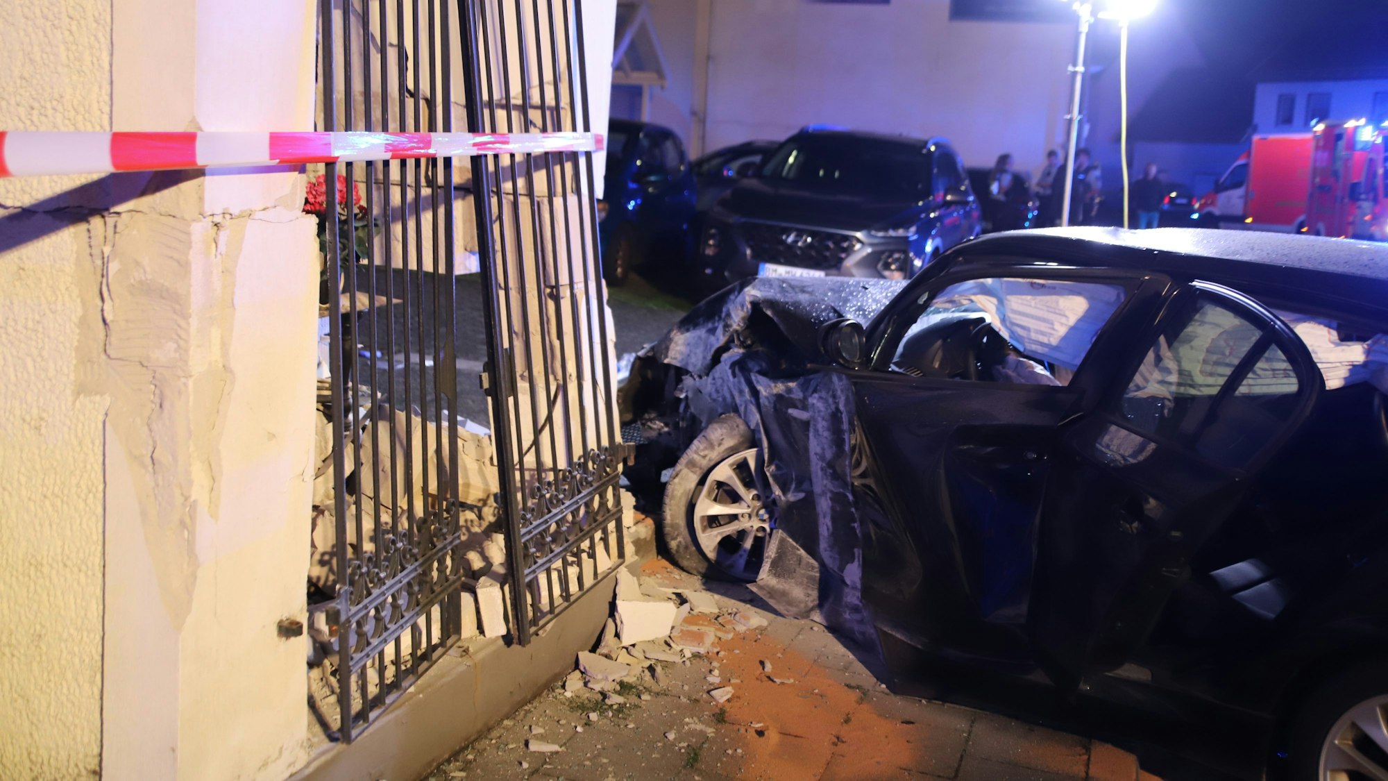 Ein schwer beschädigtes Auto steht vor einer Mauer.