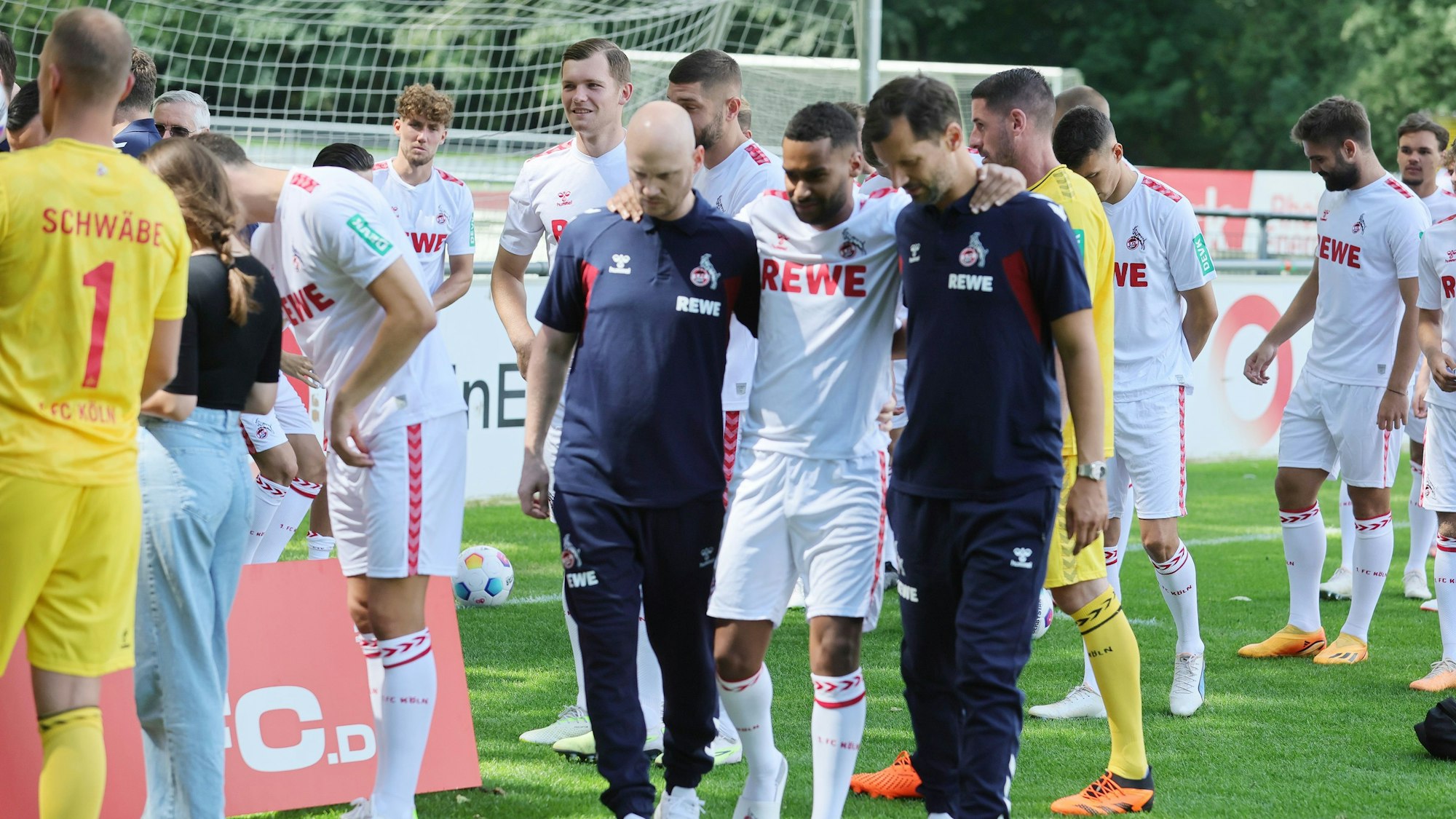 Linton Maina (M.) stieg zwar am Dienstag wieder ins Training ein, hatte aber im Anschluss Rückenschmerzen. Auf dem Weg zur Aufnahme des Mannschaftsfotos musste er gestützt werden.