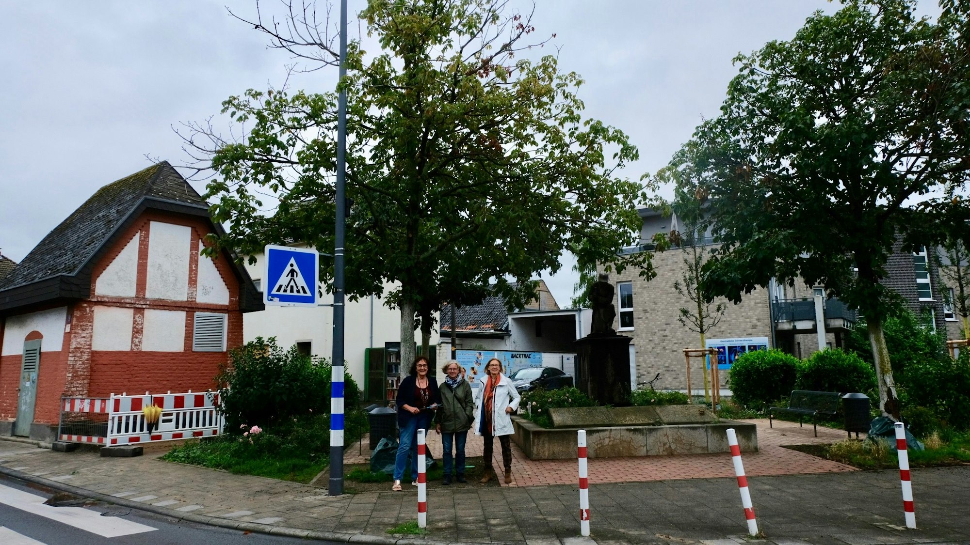 Drei Frauen stehen vor einem Baum.