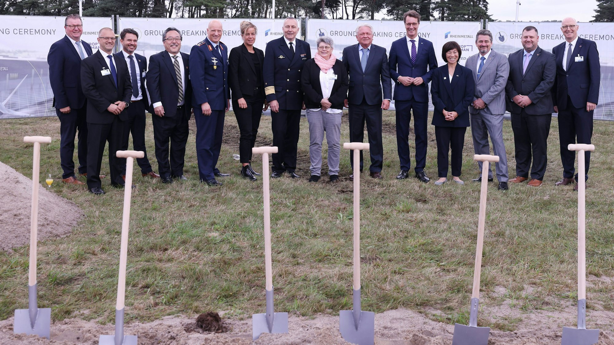 Weeze: Im Niederrrhein-Airport Weeze stehen die Entscheidungsträger der Rheinmetall-Fabrik, wo die F35B Kampfjet Rumpfmittelteile gebaut werden, nach dem symbolischen Spatenstich zusammen. Darunter Mona Neubaur und Hendrik Wüst.