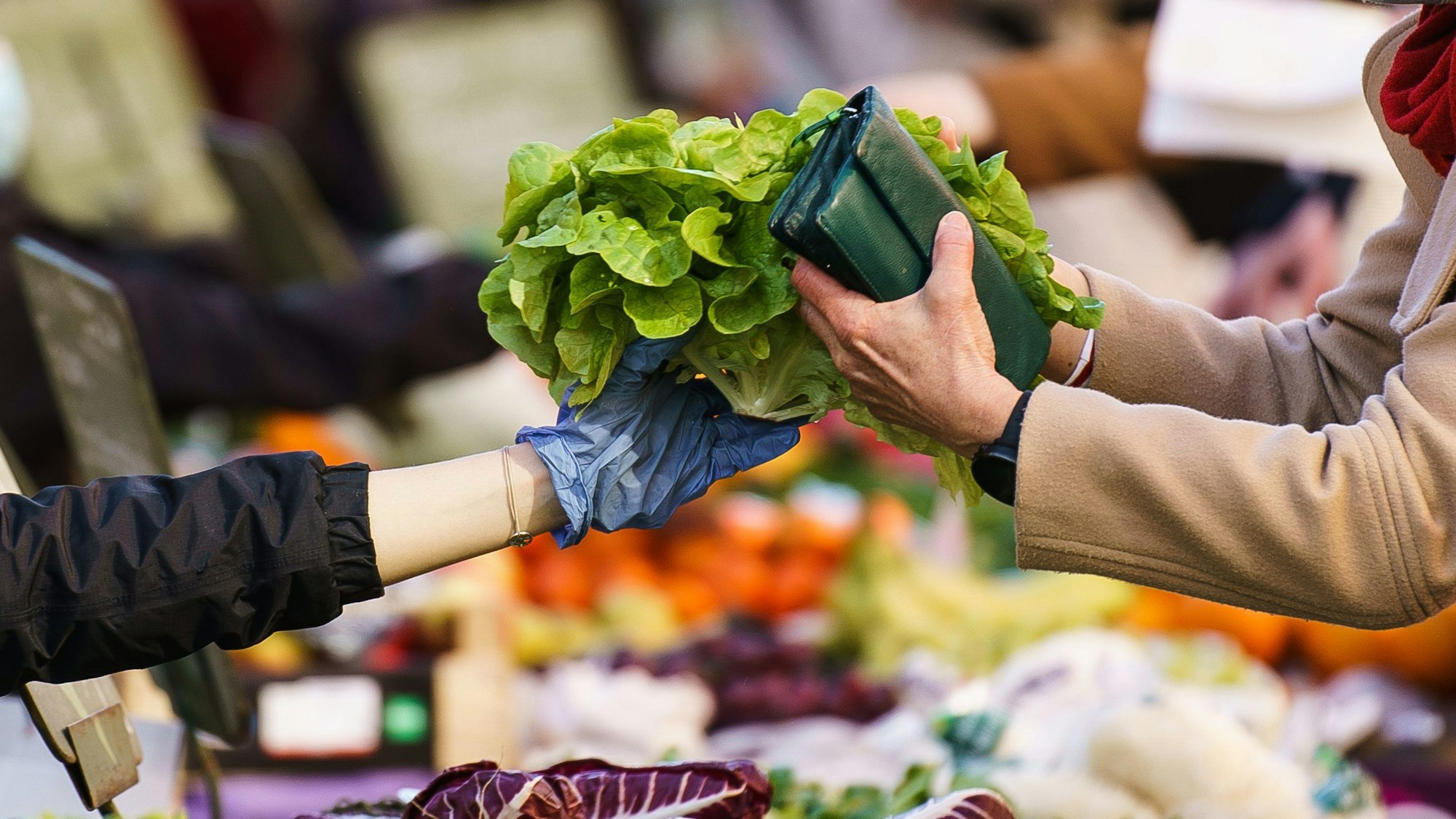 Salat wird auf dem Wochenmarkt einer Kundin gereicht