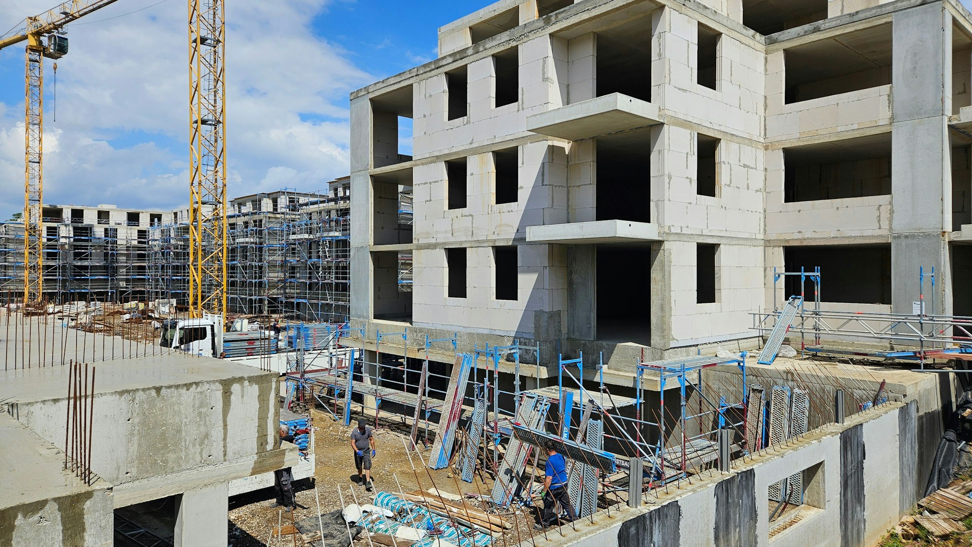 Das Bild zeigt einen Rohbau im Sonnenfeld und Baukräne.