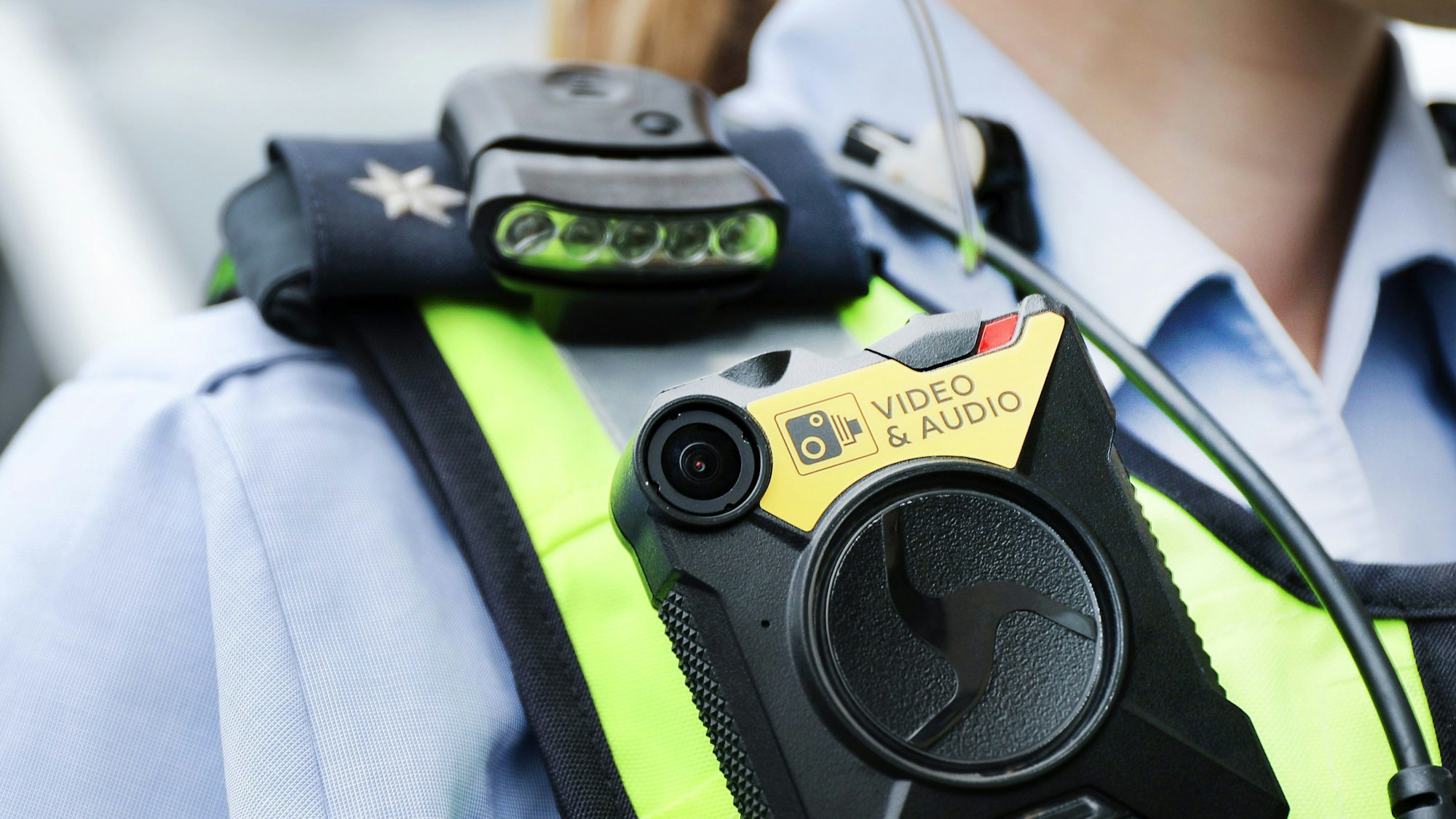 Eine Polizistin der Streifenpolizei führt eine Bodycam vor.