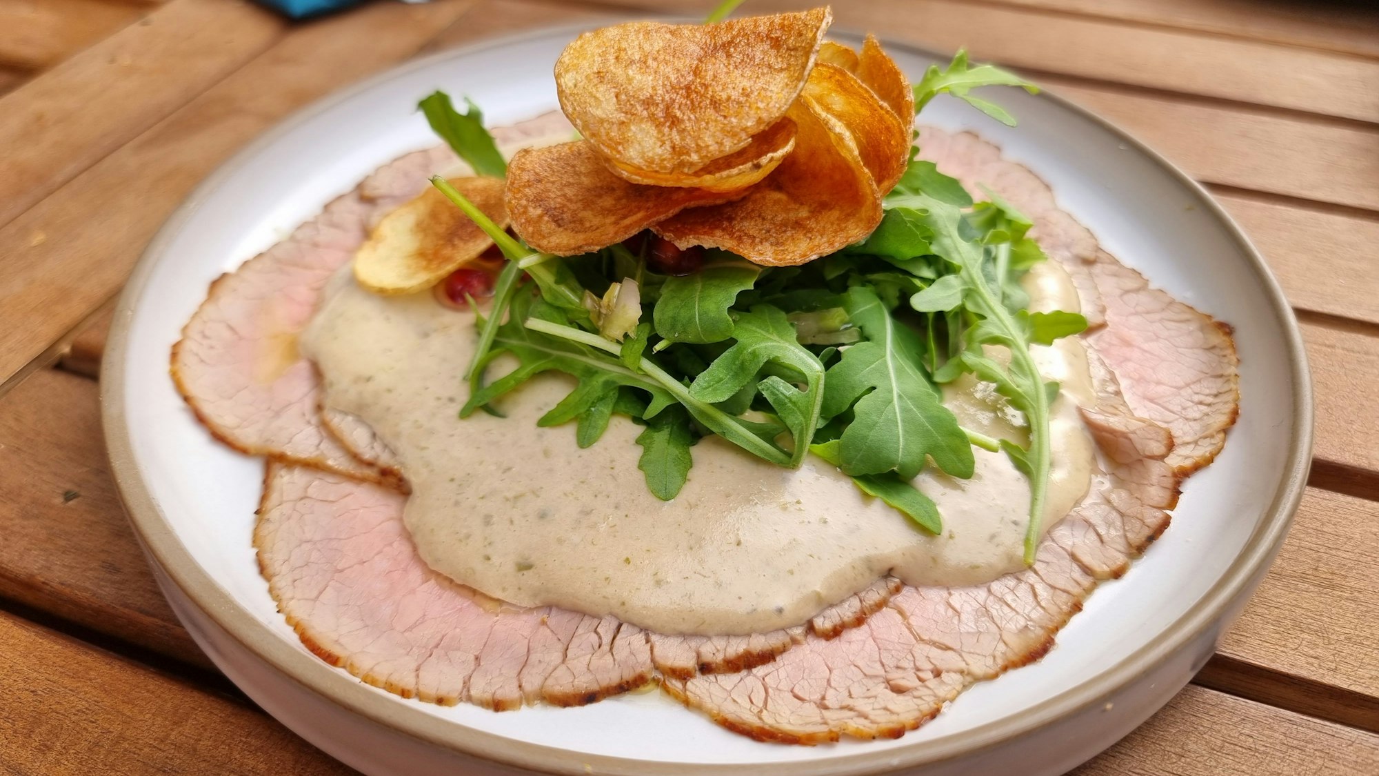 Vitello Tonnato mit Chips und Granatapfelkernen.