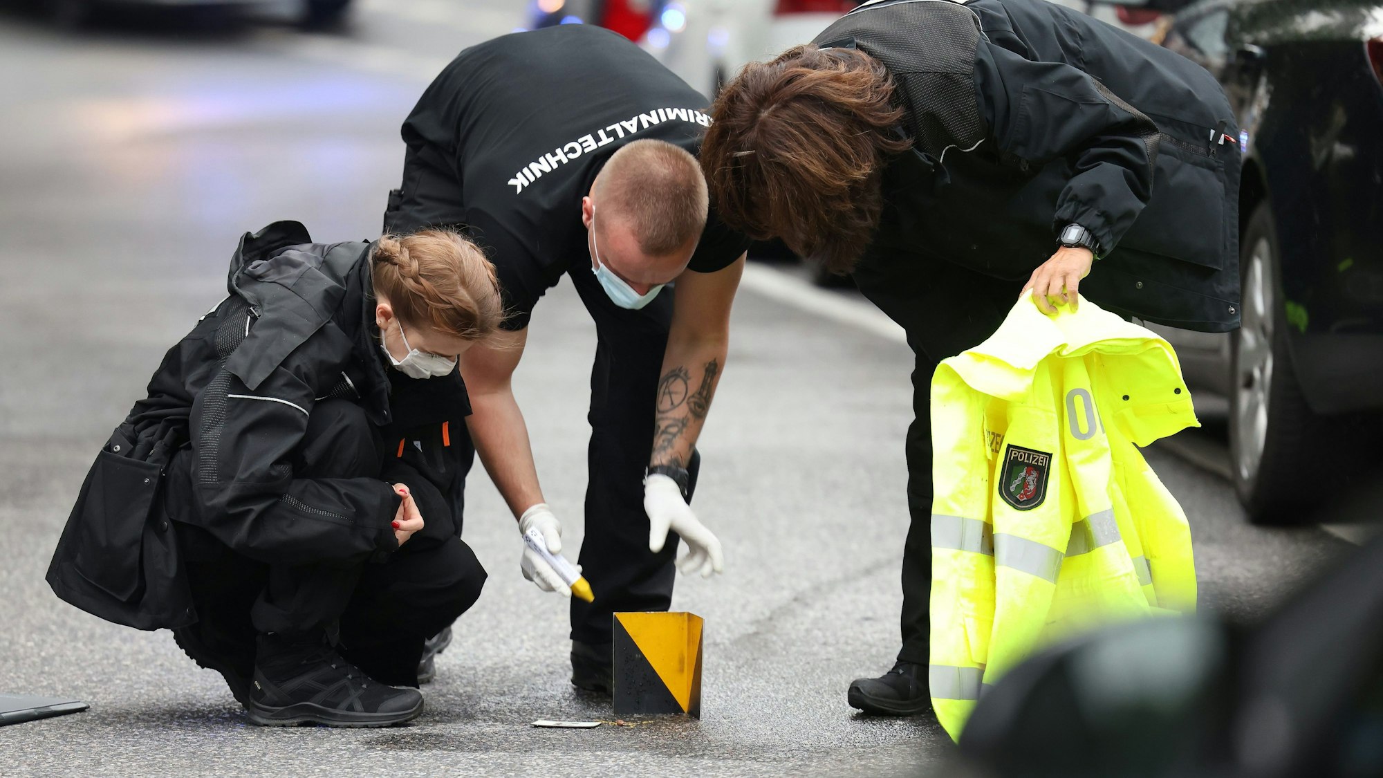 Beamte untersuchen einen Tatort und sichern ein Beweisstück. (Symbolbild)