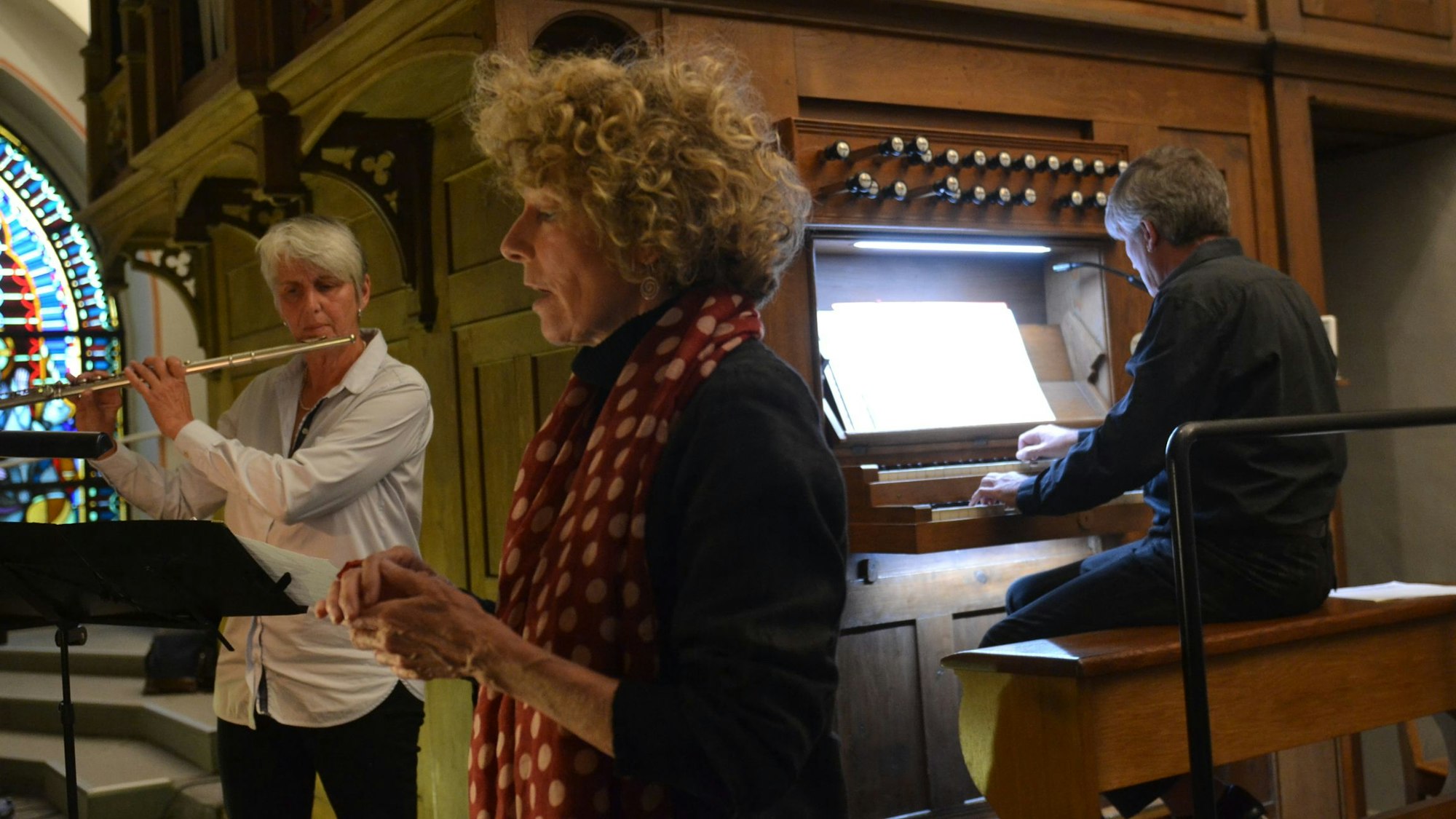Auf der Orgelempore der Kuchenheimer Kirche präsentieren die drei ihre Musik: Christiane Reuter spielt Querflöte, Henrike Ulrich singt und Markus Goecke spielt die Orgel.