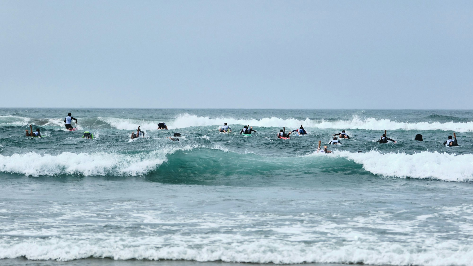 Auf dem Foto sind gut ein Dutzend Rettungsschwimmer zu sehen, die gegen die Wellen und die Uhr kämpfen.