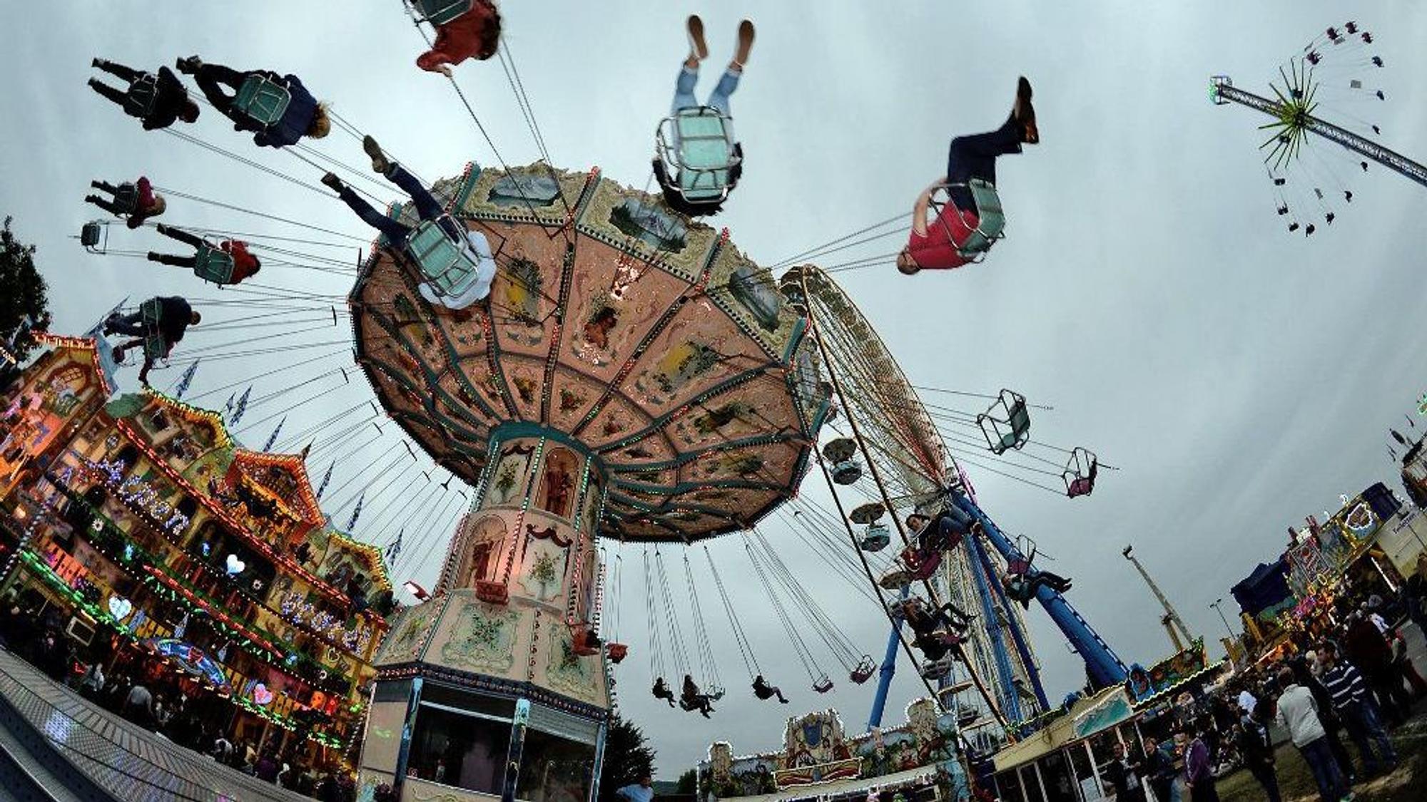 Besucher fahren in Bonn beim Jahrmarkt Pützchens Markt mit einem Kettenkarussell.