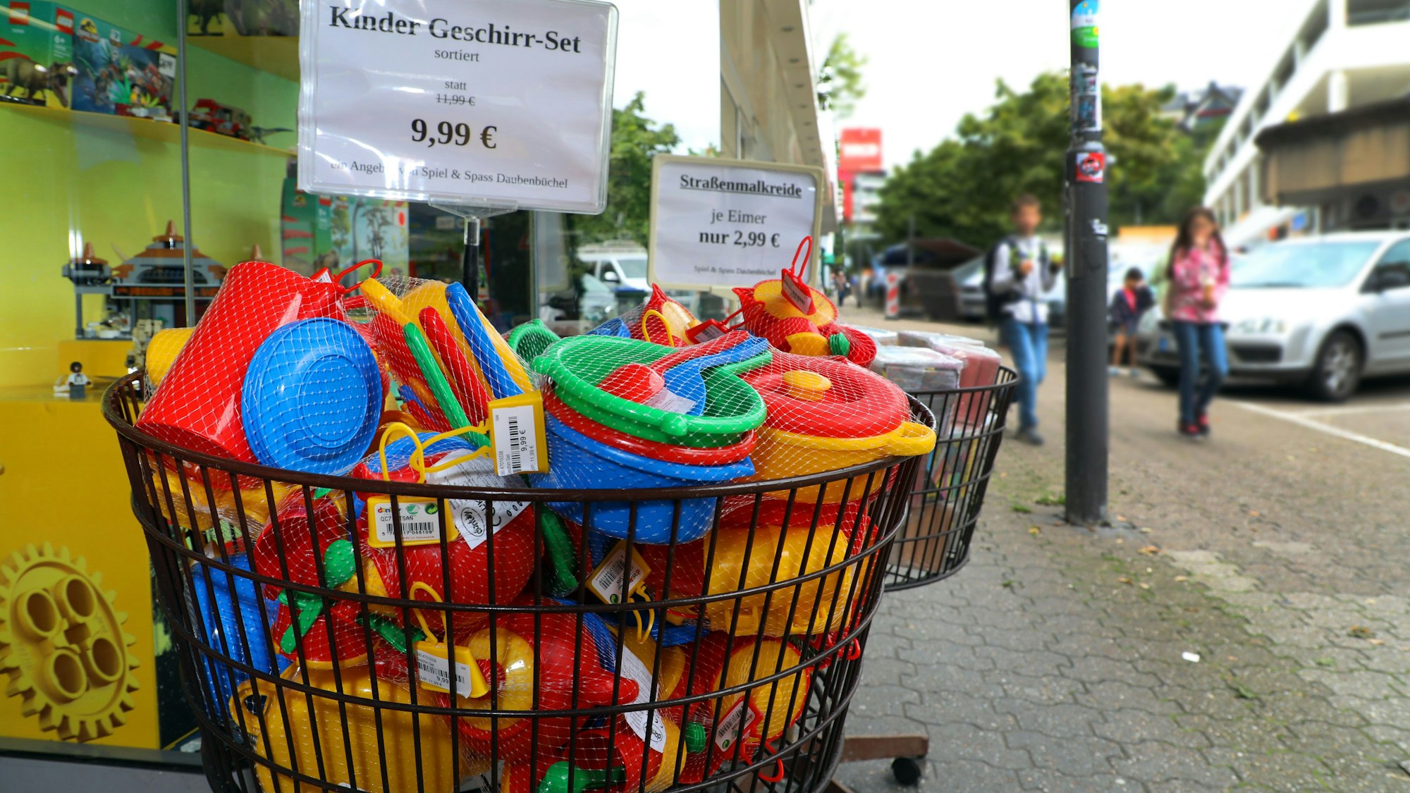 Sandspielzeug liegt in einem Korb vor dem Spielwarengeschäft „Spiel & Spaß Daubenbüchel“ an der Bensberger Schloßstraße.