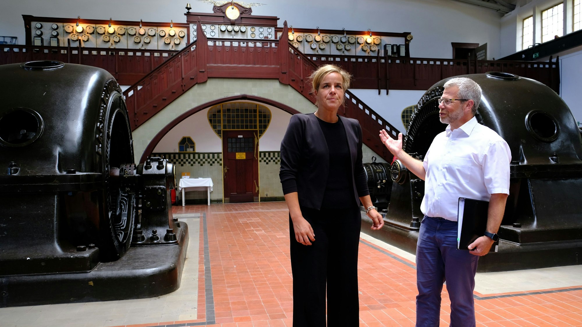 Ein Mann und eine Frau stehen im mehr als 100 Jahre alten Wasserkraftwerk in Heimbach.