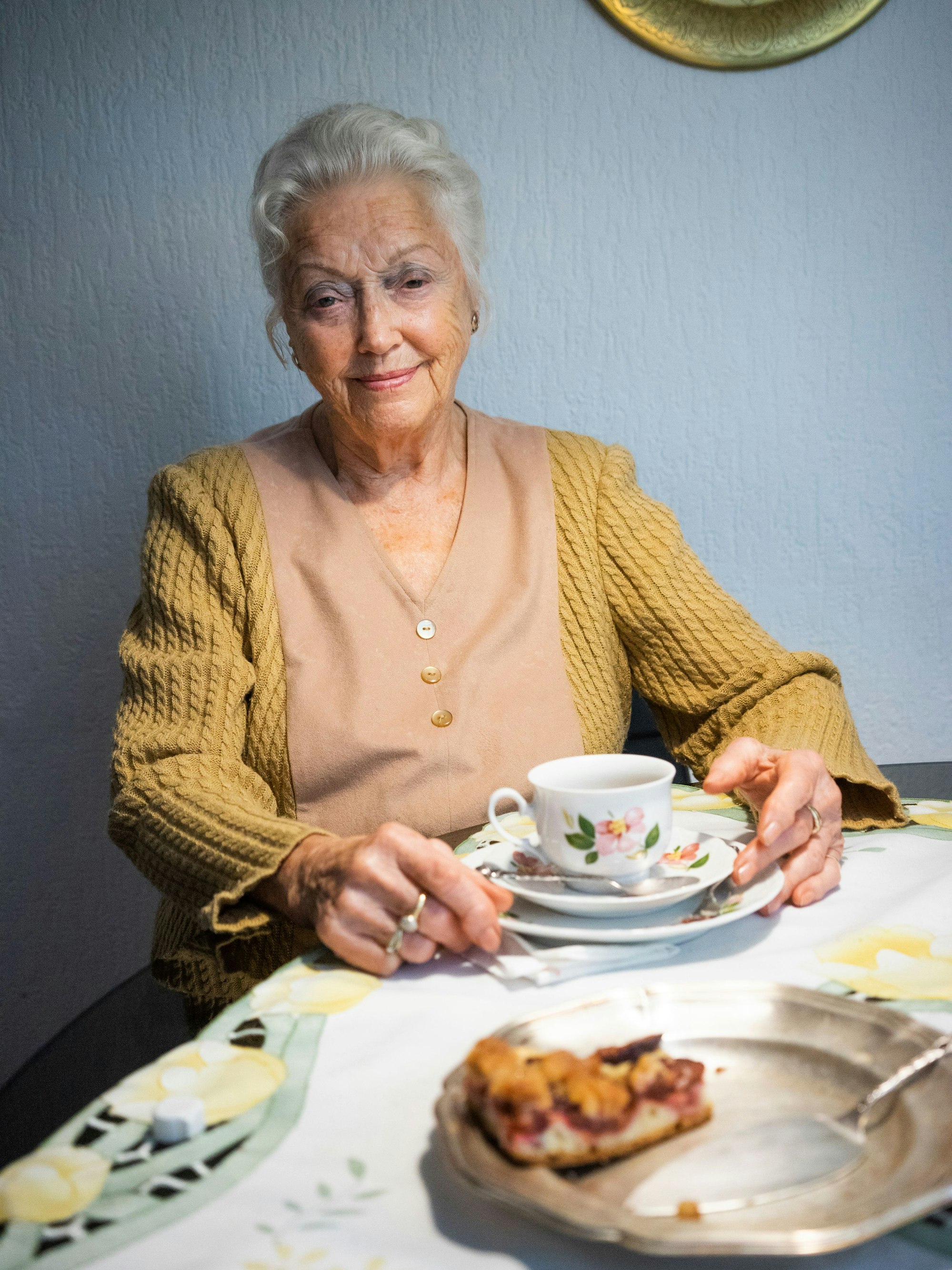 Eine ältere Frau am Kaffeetisch.