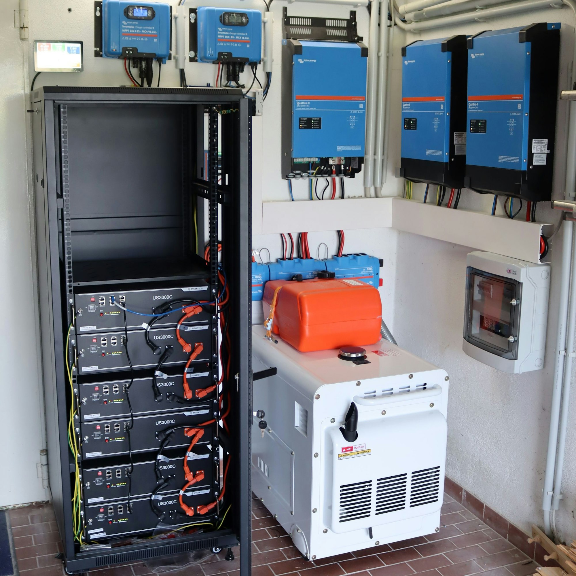 Neben den Akkus im Serverschrank sowie den Wechselrichtern und weiterer Technik an den Wänden ist auch ein Generator zu sehen.