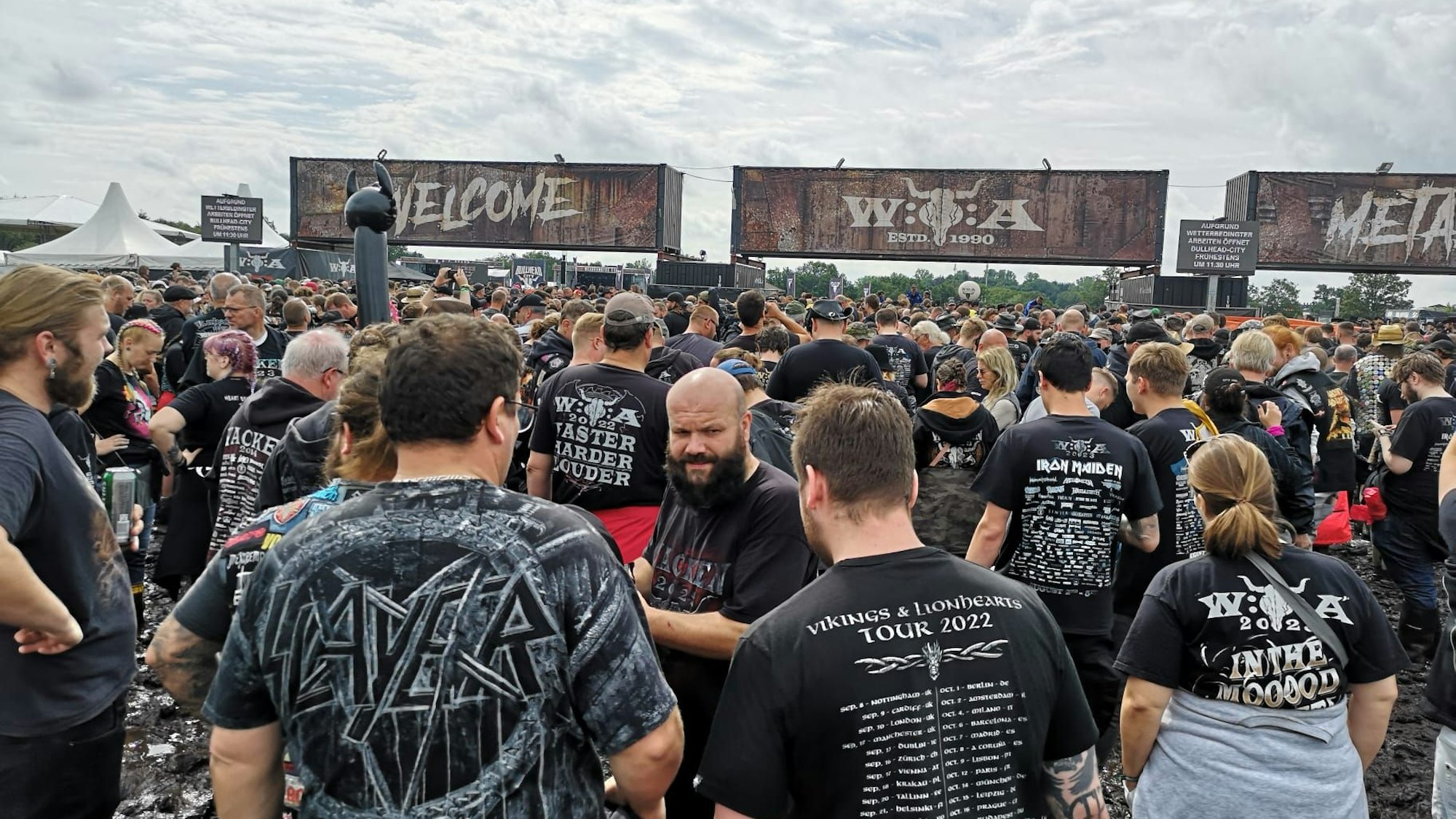 Hunderte Wacken-Besucher warten am Einlass. Gerade regnet es nicht.