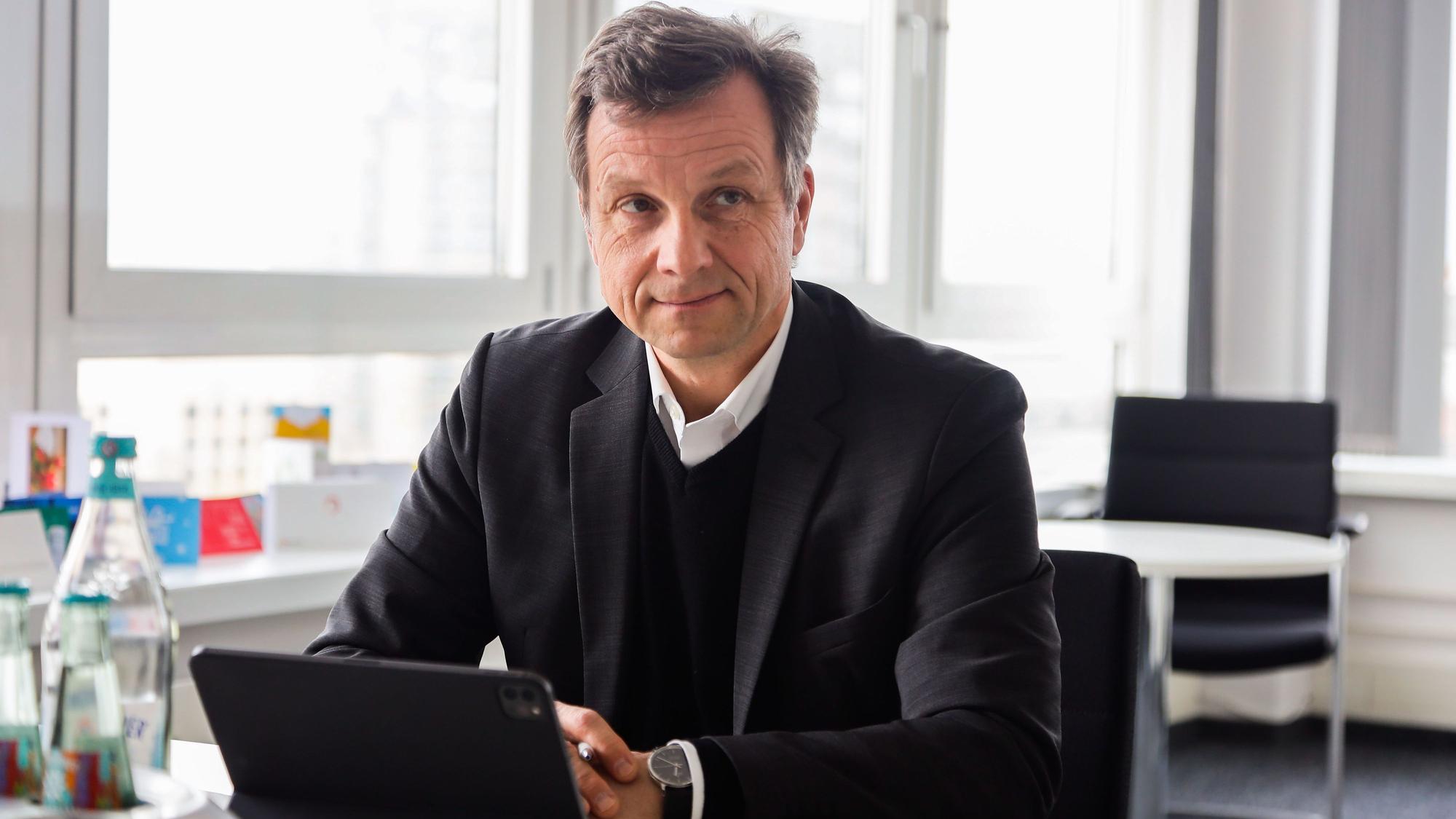 Ascan Egerer sitzt in seinem Büro im Stadthaus an einem Schreibtisch.