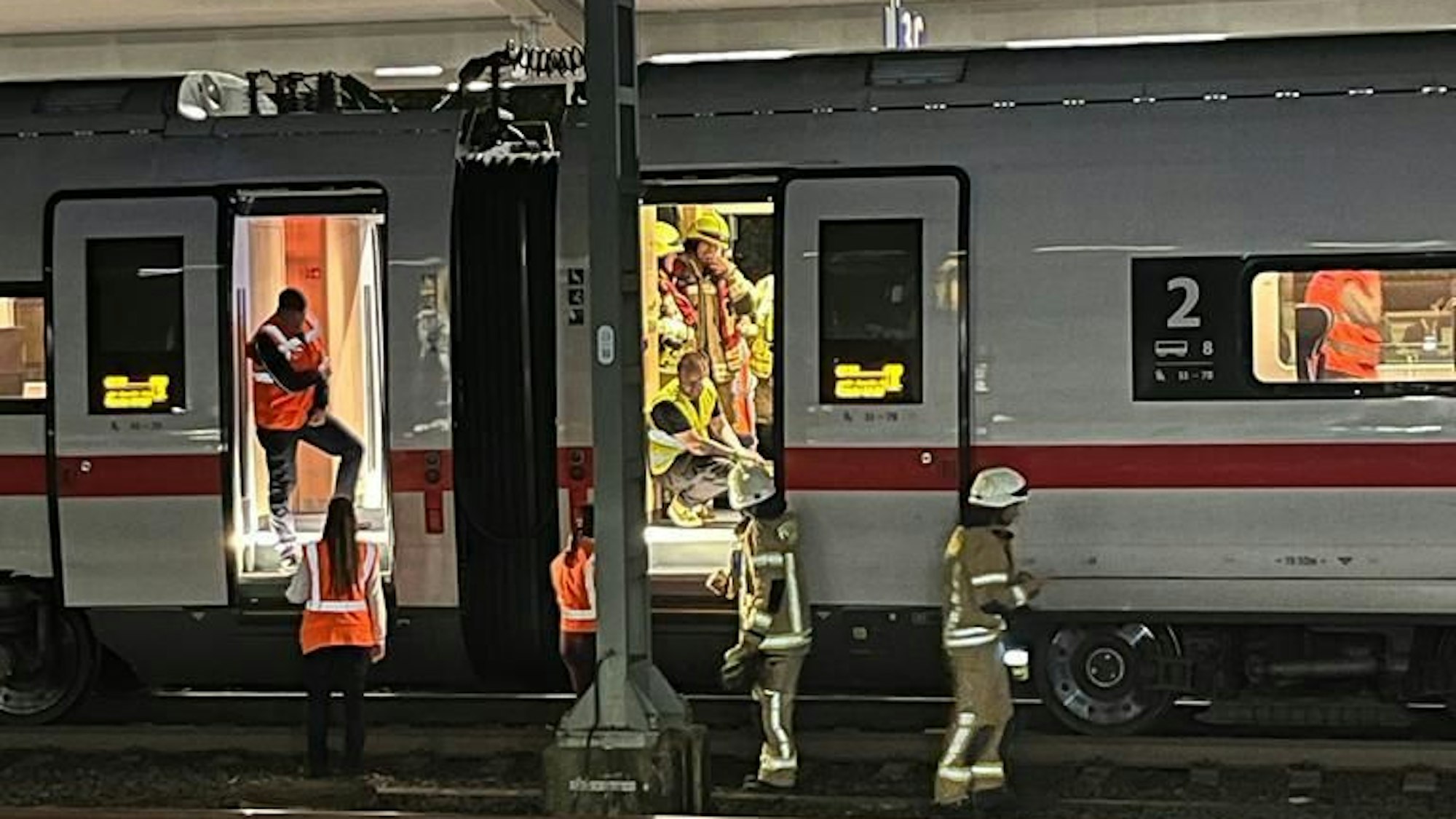 Feuerwehrleute in einem ICE am Bahnhof.
