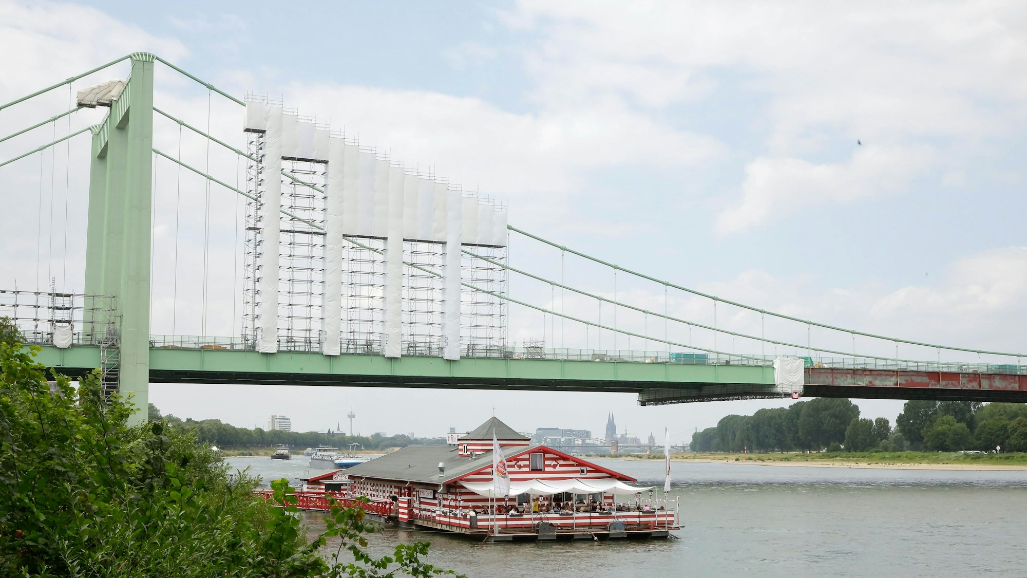 Das Bootshaus „Alte Liebe“ liegt an der Rodenkirchener Brücke im Rhein vor Anker