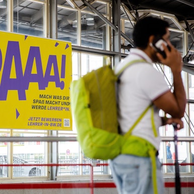 Ein Werbeplakat für den Beruf des Lehrers hängt am Flughafen in Stuttgart. An der Kampagnen gibt es scharfe Kritik.