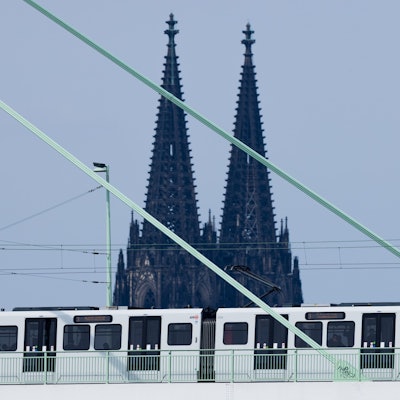 Eine Straßenbahn der Kölner Verkehrsbetriebe (KVB) fährt über die Severinsbrücke vor der Kulisse des Kölner Doms.