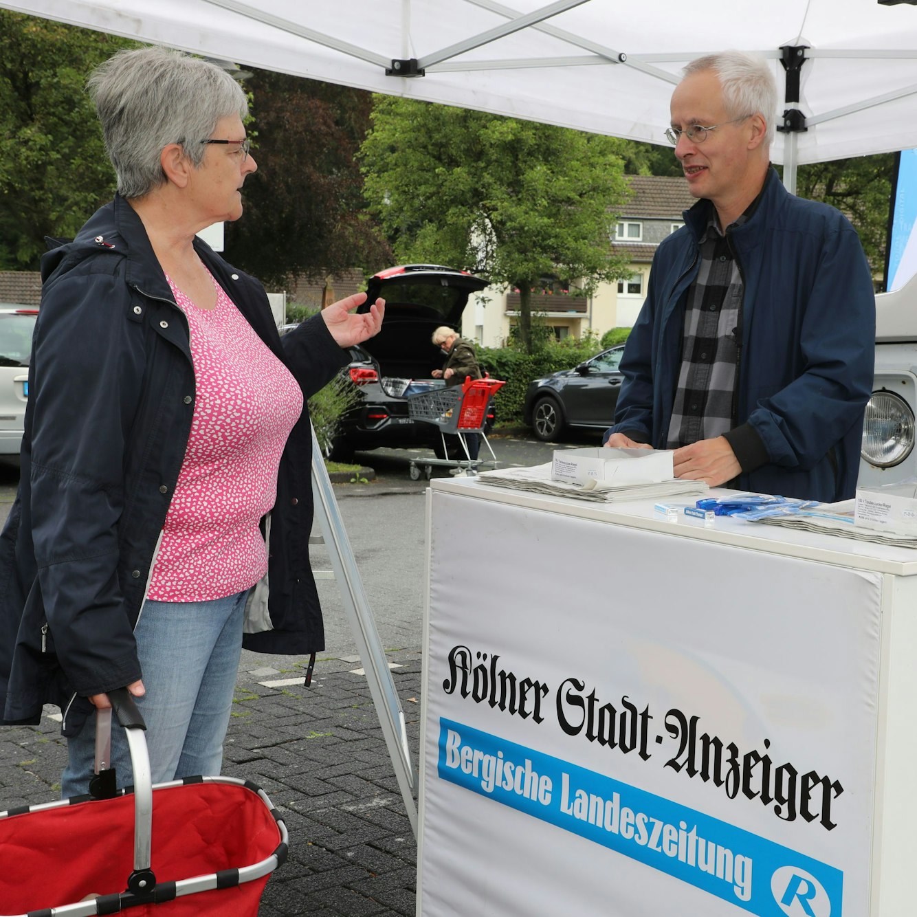 Redakteur Claus Boelen-Theile steht mit Anke Suhr am Tresen des Infostands der Redaktionssommertour.