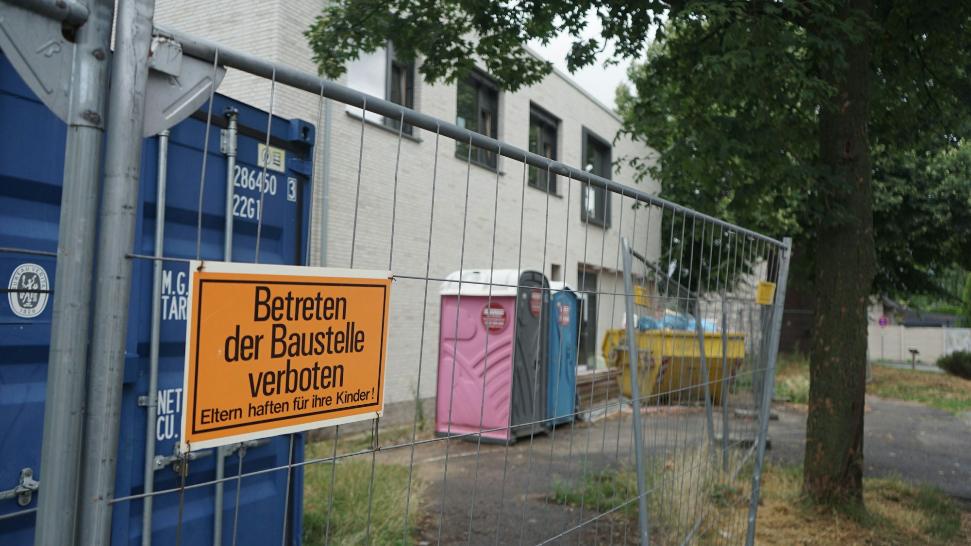 Das Bild zeigt eine Baustelle, einen Bauzaun, Dixie-Klos und das Schild "Betreten der Baustelle verboten".