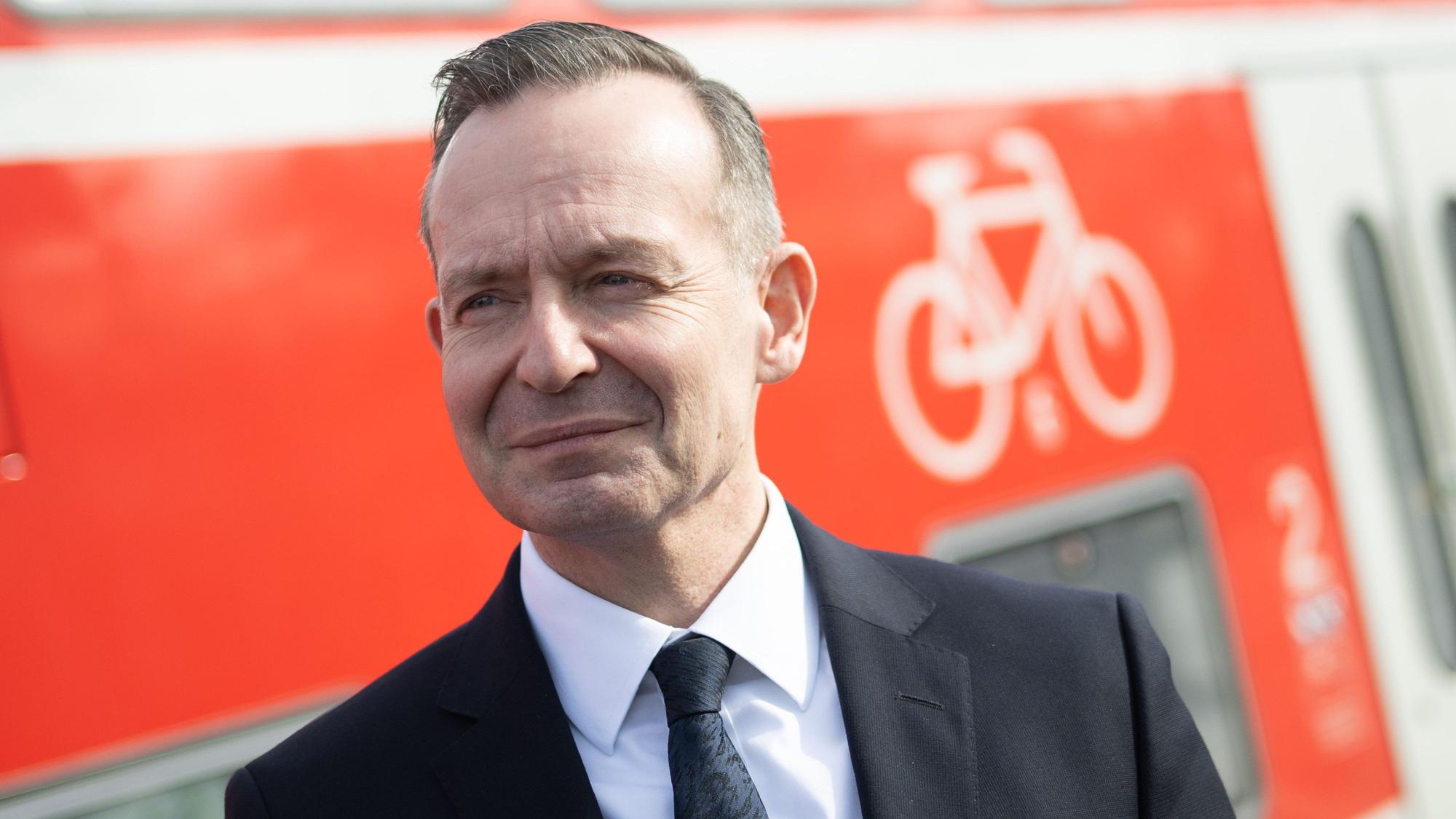 Volker Wissing steht während einer Besichtigung der Bahnstrecke Mannheim-Frankfurt am Bahnhof Lampertheim neben dem Fahrradabteil eines Regional-Expresses.